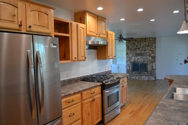104 First St, Mountain View, WY 82939 - kitchen with appliances with stainless steel finishes, under cabinet range hood, a ceiling fan, light wood-style flooring, and dark countertops