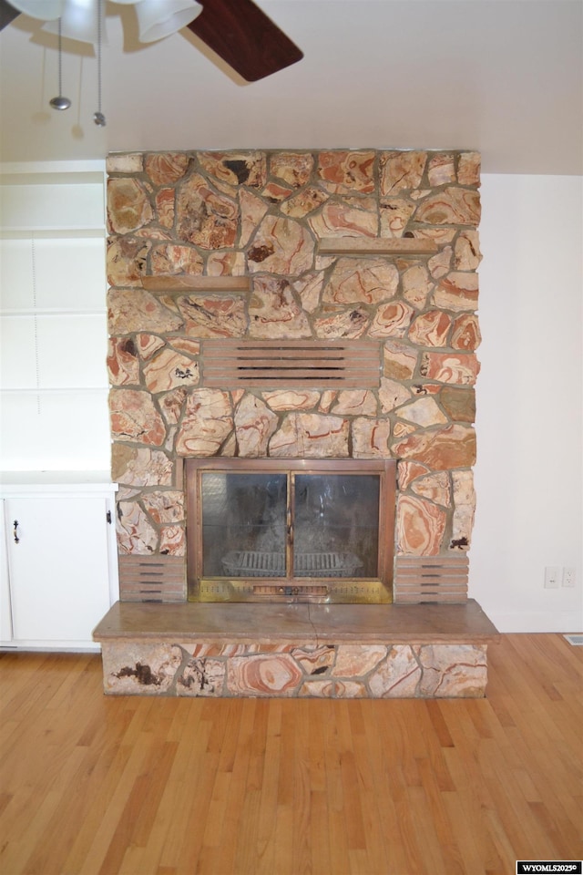 104 First St, Mountain View, WY 82939 - detailed view of a stone fireplace, a ceiling fan, and wood finished floors