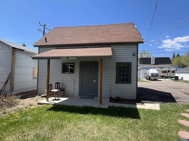 1137 Main St, Evanston, WY 82930 - back of property featuring a shingled roof and a lawn