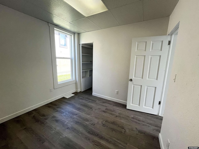 1137 Main St, Evanston, WY 82930 - unfurnished bedroom featuring dark wood-style floors, baseboards, a paneled ceiling, and a closet