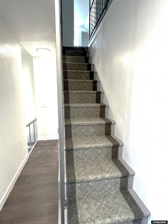 1137 Main St, Evanston, WY 82930 - staircase featuring a textured wall, wood finished floors, and baseboards