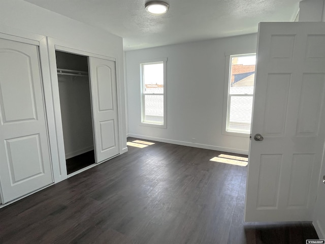 1137 Main St, Evanston, WY 82930 - unfurnished bedroom featuring dark wood-style flooring, baseboards, a closet, and a textured ceiling