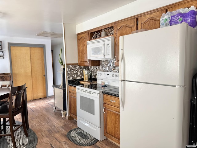 921 3RD W Ave, Kemmerer, WY 83101 - kitchen with white appliances, dark countertops, backsplash, and brown cabinetry