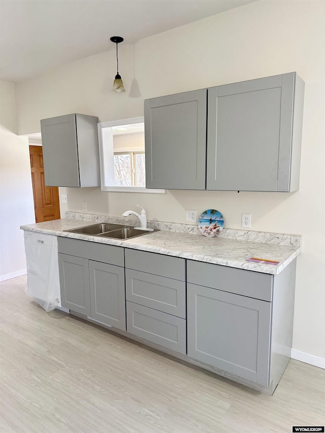 401 Quartz St, Kemmerer, WY 83101 - kitchen featuring gray cabinetry, a sink, light wood finished floors, and light countertops