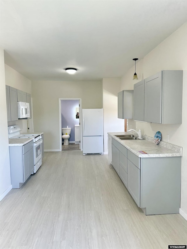 401 Quartz St, Kemmerer, WY 83101 - kitchen with white appliances, gray cabinetry, a sink, light wood-style flooring, and baseboards