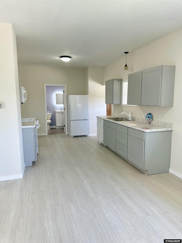 401 Quartz St, Kemmerer, WY 83101 - kitchen with white appliances, gray cabinetry, baseboards, light wood finished floors, and a sink