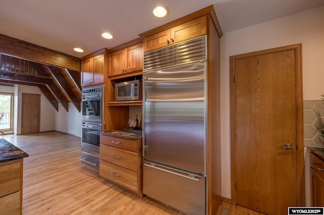 370 Aster, Casper, WY 82604 - kitchen with stainless steel appliances, light wood-style floors, dark stone counters, brown cabinets, and baseboards