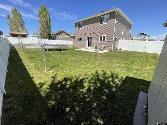 344 Via Assisi Dr, Rock Springs, WY 82901 - back of property featuring a trampoline, a patio, and a gate