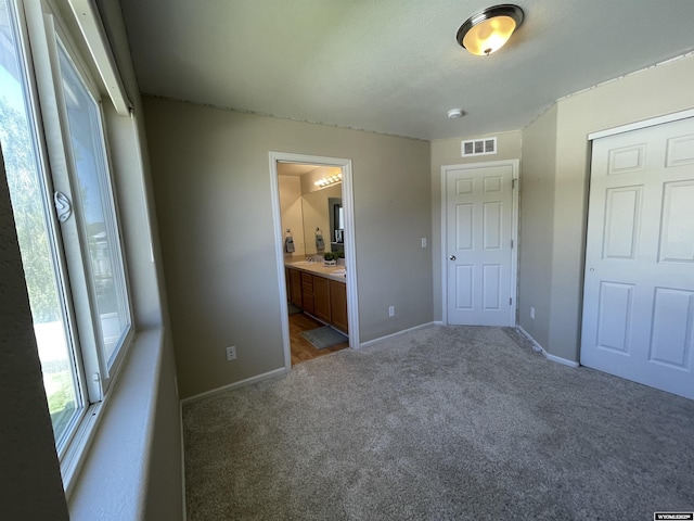 344 Via Assisi Dr, Rock Springs, WY 82901 - unfurnished bedroom with light colored carpet, baseboards, connected bathroom, and a closet