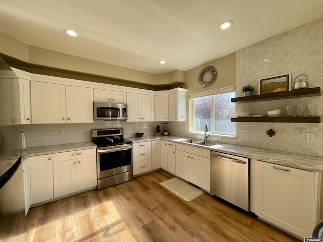 344 Via Assisi Dr, Rock Springs, WY 82901 - kitchen with stainless steel appliances, a sink, white cabinetry, backsplash, and open shelves