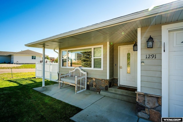 1291 Eagle View Dr, Buffalo, WY 82834 - doorway to property with a lawn, stone siding, and covered porch