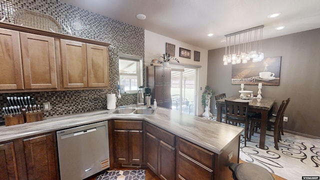 810 S 3rd Ave, Mills, WY 82604 - kitchen with stainless steel dishwasher, a sink, a peninsula, light countertops, and decorative backsplash