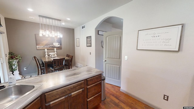 810 S 3rd Ave, Mills, WY 82604 - kitchen with arched walkways, dark wood-style flooring, a sink, baseboards, and decorative light fixtures