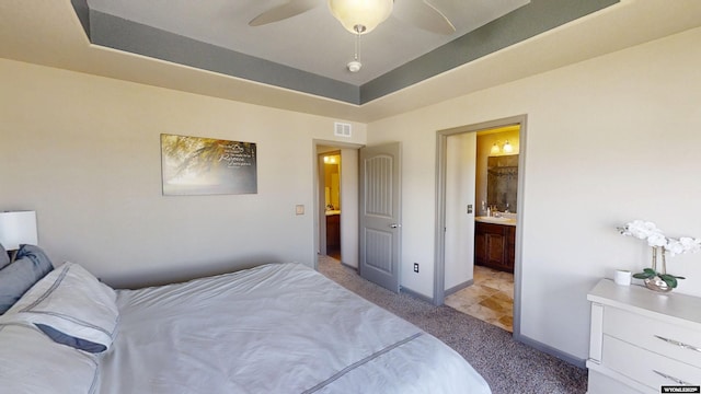 810 S 3rd Ave, Mills, WY 82604 - bedroom with light colored carpet, baseboards, a raised ceiling, ensuite bath, and ceiling fan