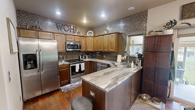 810 S 3rd Ave, Mills, WY 82604 - kitchen with appliances with stainless steel finishes, dark wood-type flooring, a sink, a peninsula, and light countertops