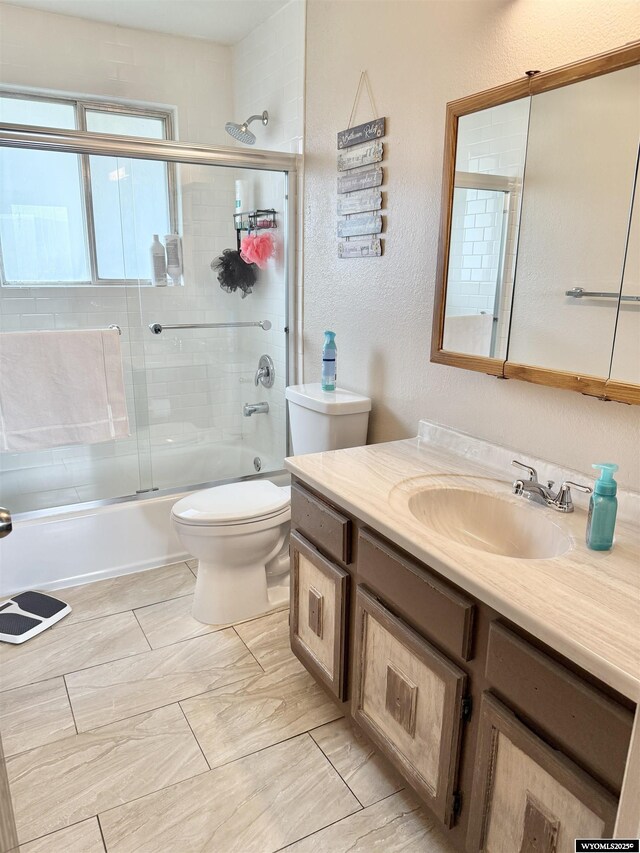 1130 Canyon Rd, Kemmerer, WY 83101 - full bath featuring vanity, bath / shower combo with glass door, toilet, and a textured wall