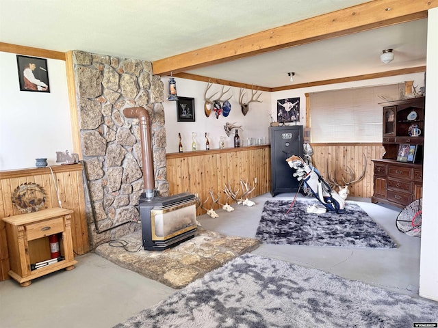 1130 Canyon Rd, Kemmerer, WY 83101 - living area with a wood stove, beamed ceiling, and wood walls