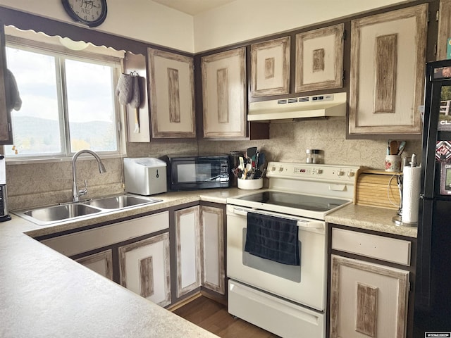 1130 Canyon Rd, Kemmerer, WY 83101 - kitchen featuring black appliances, under cabinet range hood, a sink, and light countertops