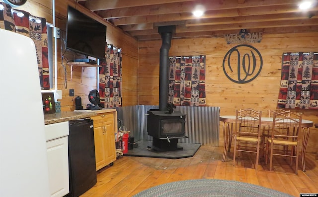 1725 E End Rd, Casper, WY 82601 - kitchen featuring wooden walls, a wood stove, light wood-type flooring, freestanding refrigerator, and refrigerator