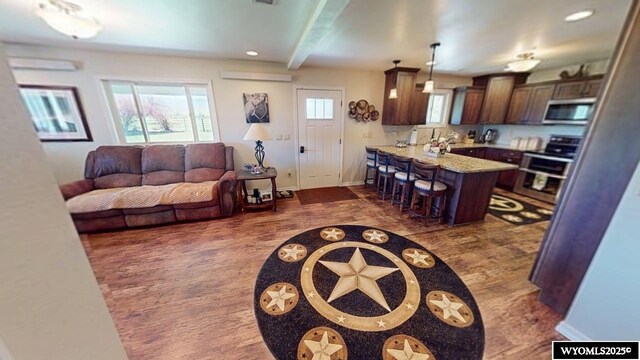 200 Irwin Ln, Lander, WY 82520 - living room with baseboards, beamed ceiling, dark wood finished floors, an AC wall unit, and recessed lighting