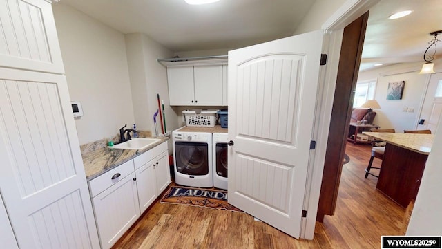 200 Irwin Ln, Lander, WY 82520 - laundry area with cabinet space, washing machine and clothes dryer, and light wood-style flooring