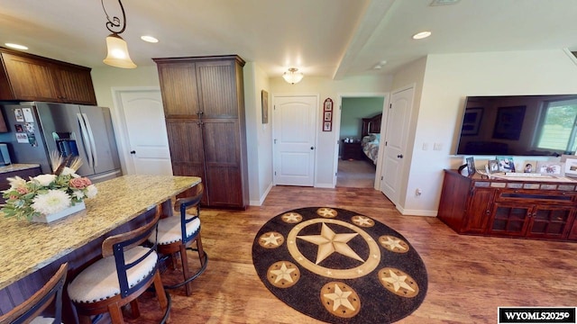 200 Irwin Ln, Lander, WY 82520 - kitchen with stainless steel fridge with ice dispenser, wood finished floors, a kitchen bar, baseboards, and recessed lighting