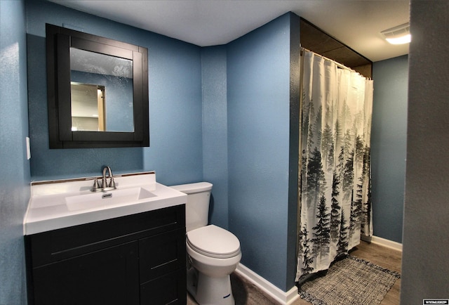 6653 Natrona Rd, Natrona, WY 82646 - full bath featuring toilet, vanity, wood finished floors, baseboards, and curtained shower