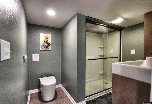 6653 Natrona Rd, Natrona, WY 82646 - full bath with a textured wall, toilet, a shower stall, vanity, and wood finished floors