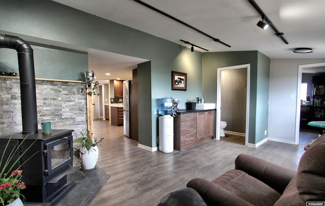 6653 Natrona Rd, Natrona, WY 82646 - living area with a wood stove, track lighting, wood finished floors, and baseboards