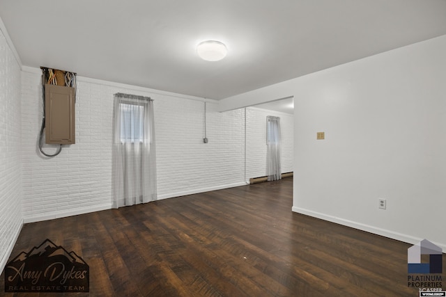 1131 W 60th St, Casper, WY 82601 - spare room featuring brick wall, wood finished floors, and baseboards