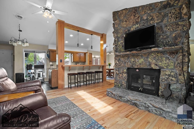 1131 W 60th St, Casper, WY 82601 - living room featuring ceiling fan, wood finished floors, a chandelier, a fireplace, and high vaulted ceiling