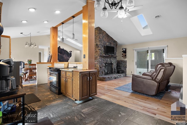 1131 W 60th St, Casper, WY 82601 - kitchen with electric range, ceiling fan, open floor plan, a skylight, and a fireplace