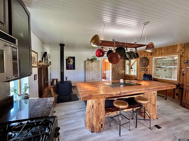 2609 Beaver Creek Rd, Shell, WY 82441 - dining space featuring a wood stove, light wood-style flooring, and wooden walls