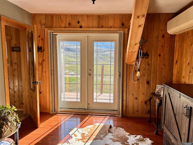 2609 Beaver Creek Rd, Shell, WY 82441 - entryway with a wall unit AC, wooden walls, wood-type flooring, french doors, and baseboards