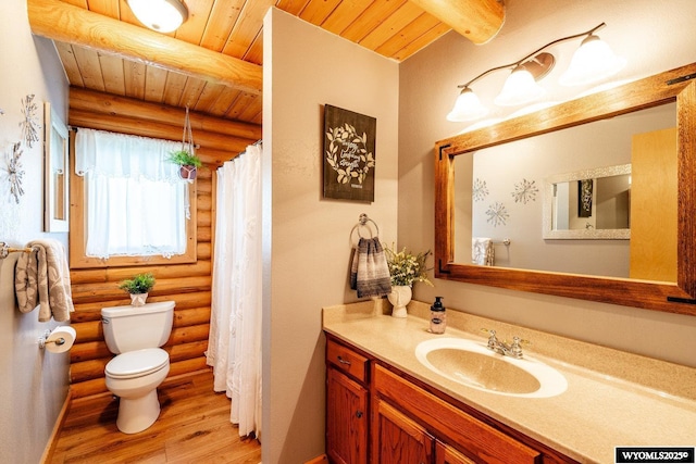 49 Cheyenne Rd, Banner, WY 82832 - full bathroom with log walls, toilet, wood finished floors, vanity, and wood ceiling with exposed beams