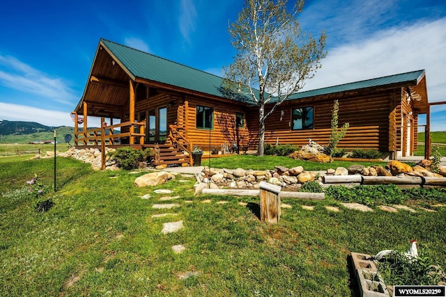 49 Cheyenne Rd, Banner, WY 82832 - view of front of house featuring log siding, metal roof, and a front lawn