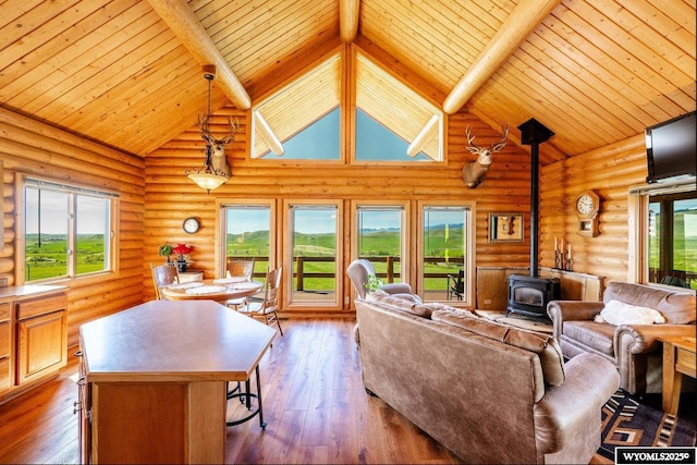 49 Cheyenne Rd, Banner, WY 82832 - living room featuring a wood stove, wood ceiling with exposed beams, high vaulted ceiling, wood-type flooring, and rustic walls
