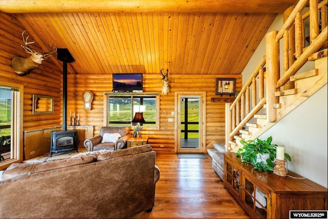 49 Cheyenne Rd, Banner, WY 82832 - living room with a wood stove, log walls, stairway, hardwood / wood-style flooring, and wooden ceiling