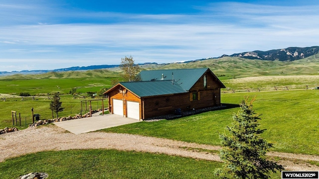 49 Cheyenne Rd, Banner, WY 82832 - view of outdoor structure with concrete driveway, a mountain view, a garage, and a view of countryside