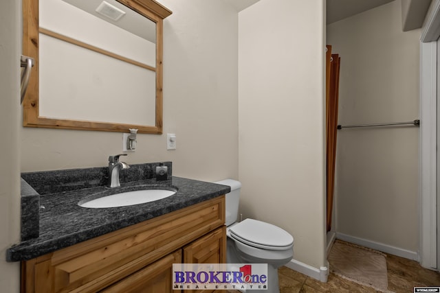 2511 Mercy Ln, Casper, WY 82609 - full bathroom featuring toilet, vanity, baseboards, a shower, and tile patterned floors
