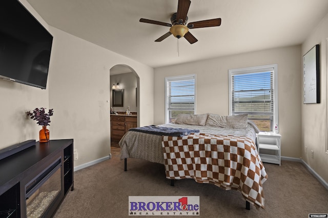 2511 Mercy Ln, Casper, WY 82609 - bedroom with carpet floors, arched walkways, ensuite bath, and baseboards