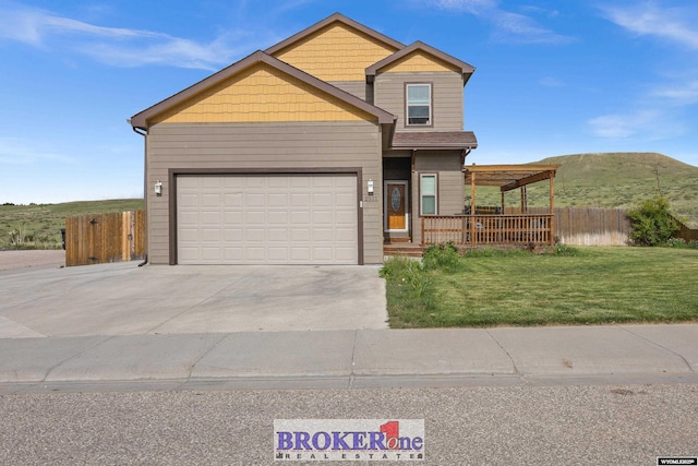 2511 Mercy Ln, Casper, WY 82609 - view of front of home featuring concrete driveway, an attached garage, a mountain view, and covered porch