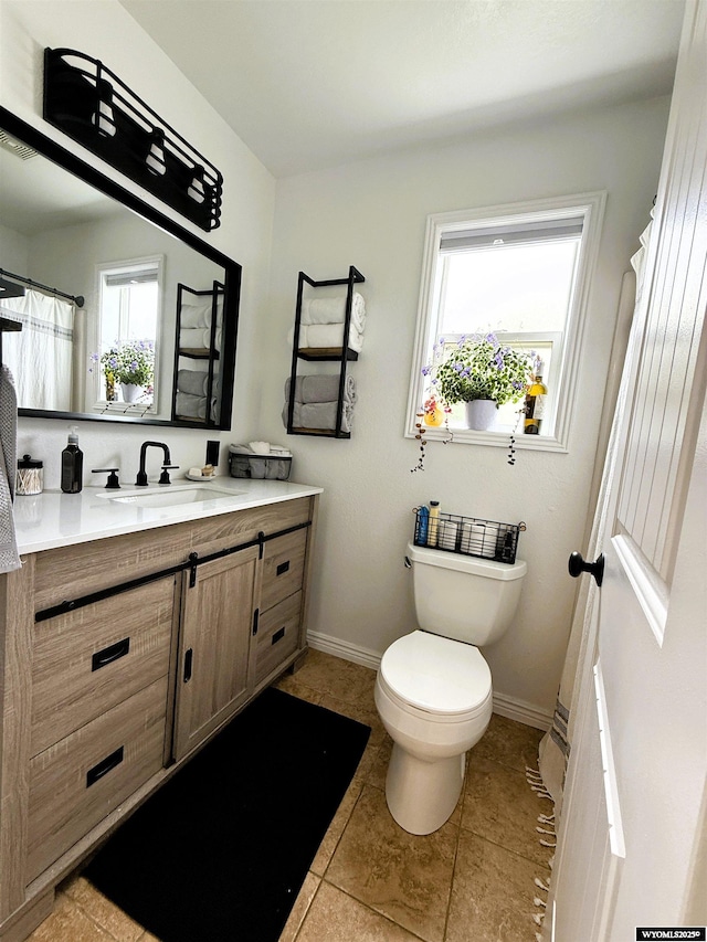 1216 Charles Ave, Worland, WY 82401 - full bath featuring vanity, toilet, baseboards, and tile patterned floors
