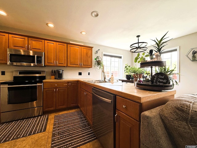 1216 Charles Ave, Worland, WY 82401 - kitchen with appliances with stainless steel finishes, a sink, recessed lighting, brown cabinets, and tile patterned floors