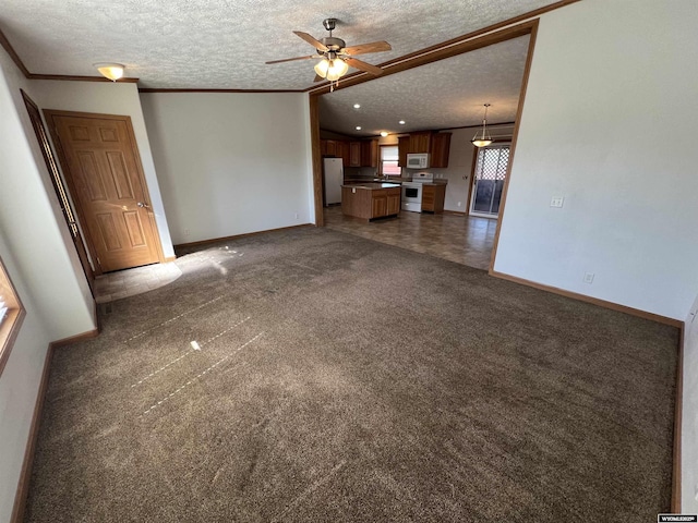 1426 Pinecrest, Riverton, WY 82501 - unfurnished living room featuring a textured ceiling, baseboards, dark colored carpet, a ceiling fan, and ornamental molding