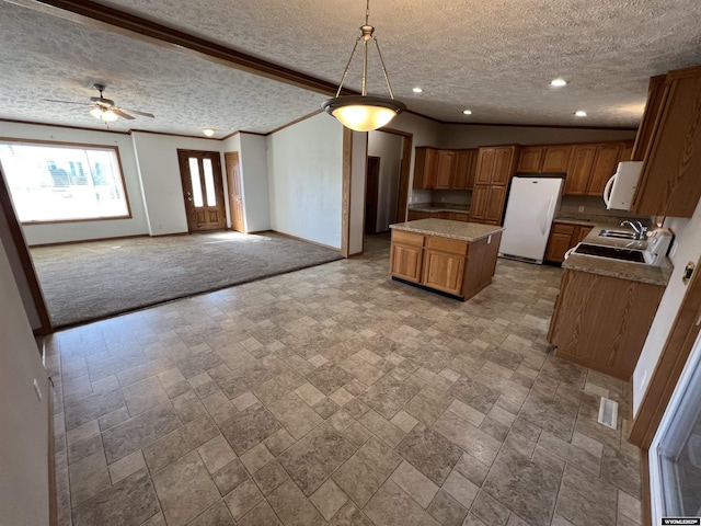 1426 Pinecrest, Riverton, WY 82501 - kitchen featuring white appliances, baseboards, a textured ceiling, a center island, and brown cabinets