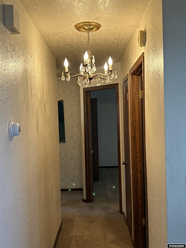 221 Rimrock Dr, Evanston, WY 82930 - hall with a textured wall, a chandelier, a textured ceiling, and carpet flooring
