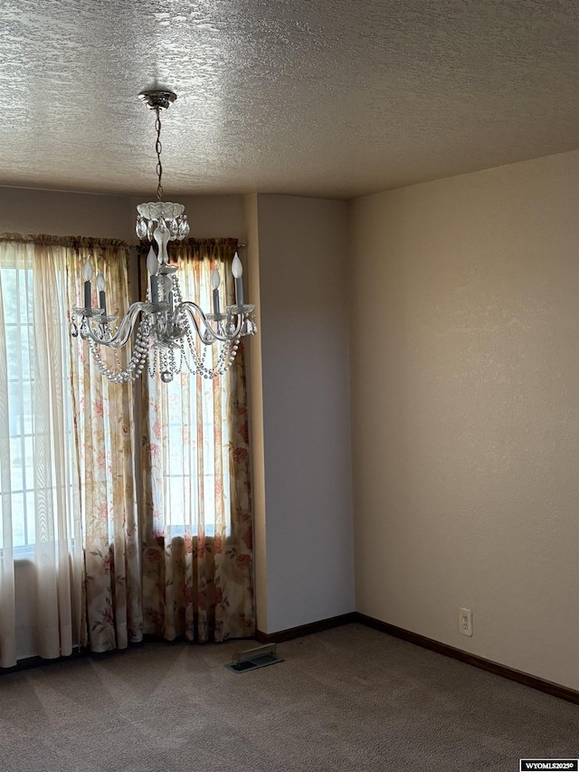 221 Rimrock Dr, Evanston, WY 82930 - carpeted spare room with a chandelier, a textured ceiling, and baseboards