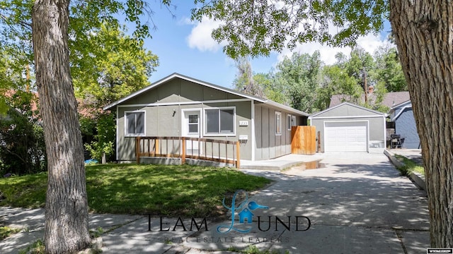 1235 S Durbin St, Casper, WY 82601 - view of front of house with concrete driveway, a detached garage, an outbuilding, and a front yard