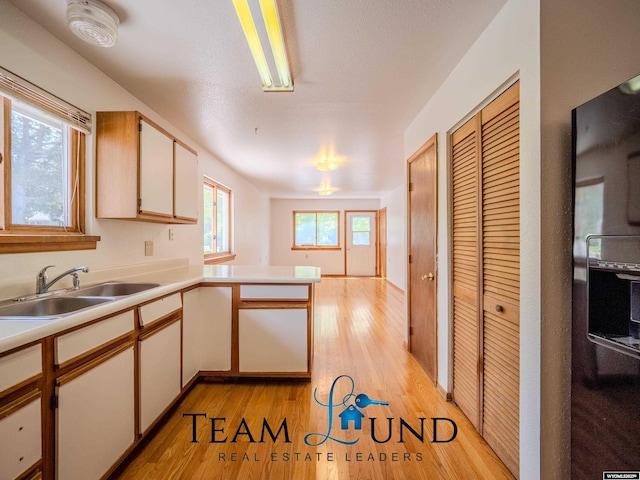 1235 S Durbin St, Casper, WY 82601 - kitchen featuring a sink, light wood-style floors, light countertops, and a peninsula